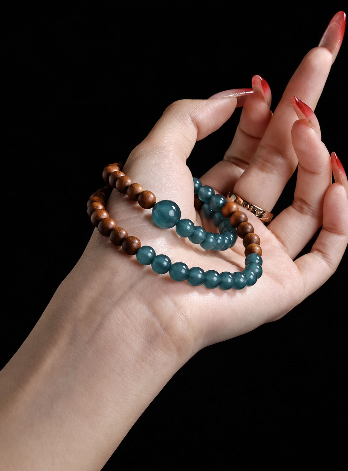 No. 07: teal and charcoal beads held in a hand